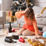 頭を押さえて床に座る女性