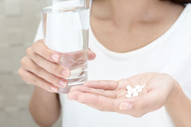 サプリを飲む女性